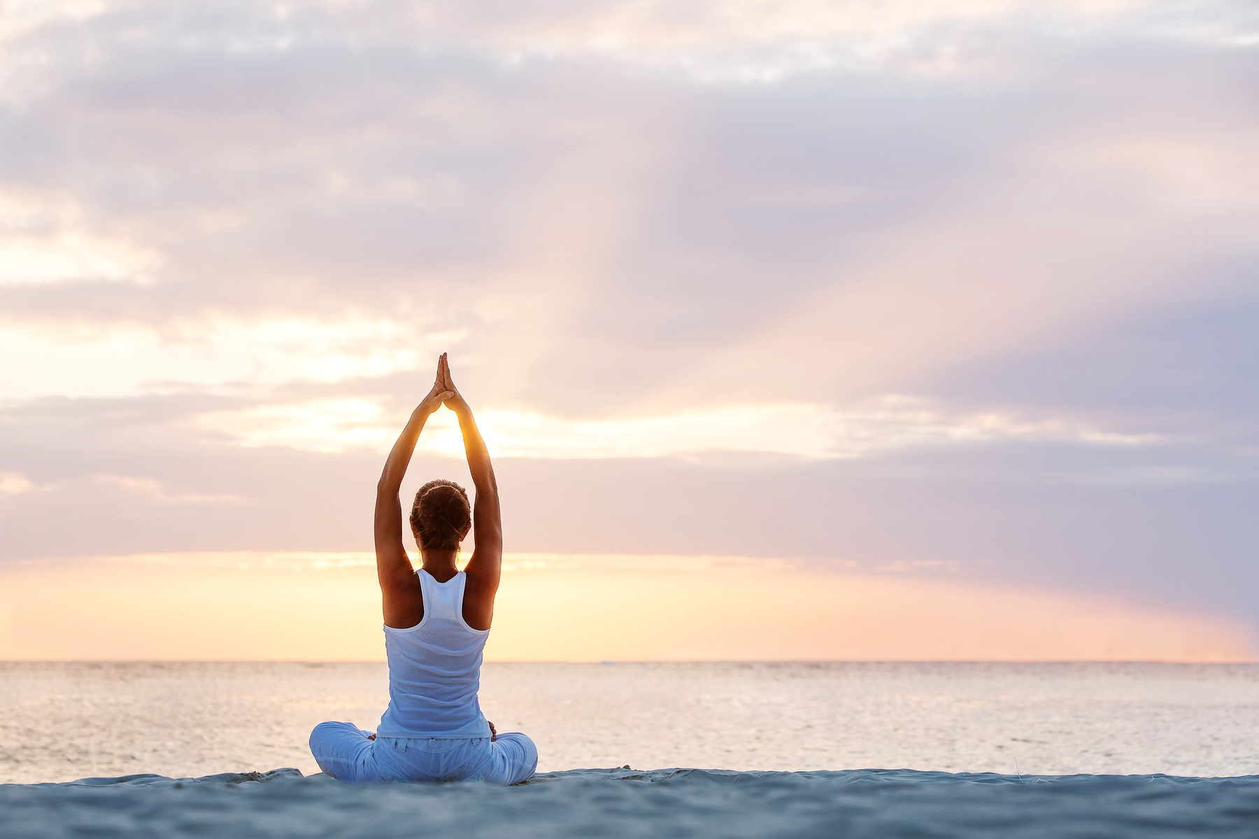 Caucasian woman practicing yoga at seashore